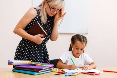Okul çocuk ders çalışma. Öğretmen kontrol öğrenme süreci.