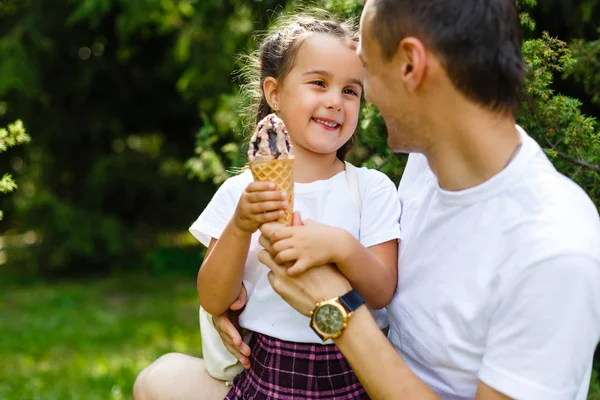 Adorable kid girl don\'t want to share ice cream to father. Family lifestyle