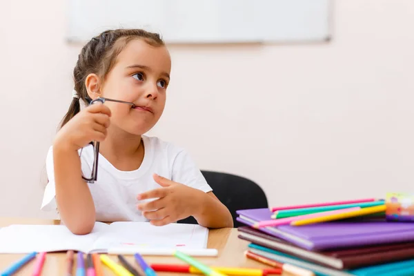 Smart Liten Skolejente Briller Ved Bordet Med Bøker Som Prøver – stockfoto