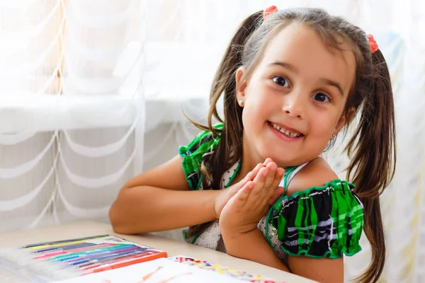 Smiling angel-like beautiful child painting . Charming little girl drawing picture for her father, preparing birthday surprise for him.