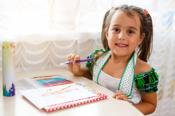 Smiling angel-like beautiful child painting . Charming little girl drawing picture for her father, preparing birthday surprise for him.