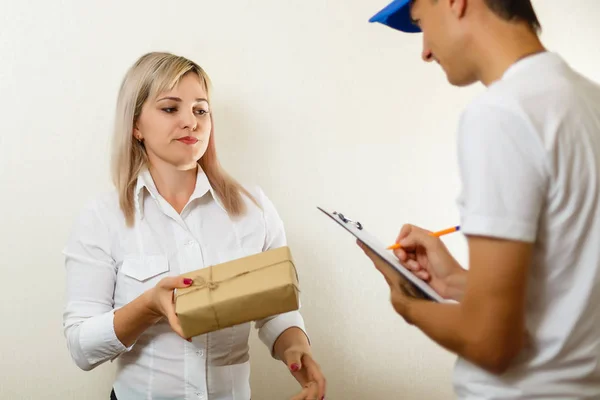 View Young Woman Signing Receiving Box Delivery Man — стоковое фото