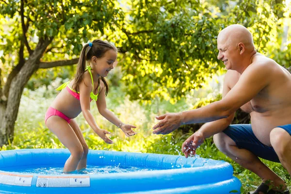 Großvater Mit Enkelin Spielt Aufblasbaren Pool — Stockfoto