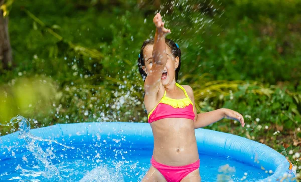 Küçük Kız Yeşil Bahçesinde Şişme Havuzda Eğleniyor — Stok fotoğraf