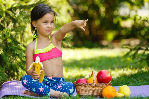 Jovem Sentada Cobertor Perto Cesta Frutas Segurando Banana Almoçando — Fotografia de Stock