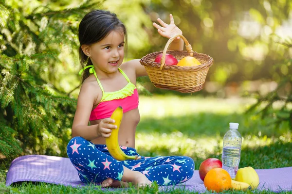 Jovem Sentada Cobertor Perto Cesta Frutas Segurando Banana Almoçando — Fotografia de Stock