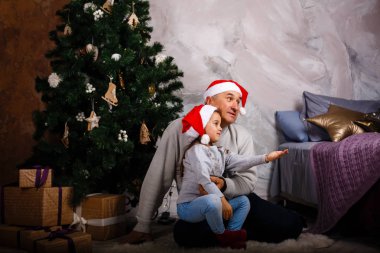 Küçük kız Noel ağacı evde oturan dedesi ile eğleniyor 