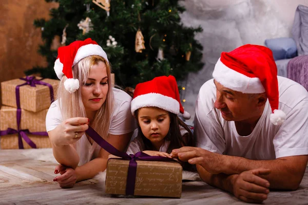 老人の孫娘とクリスマス ツリーの近くの娘と過ごす時間のサンタ帽子 — ストック写真