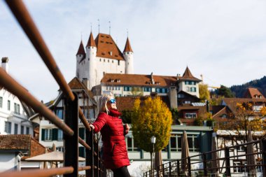 Yetişkin kadın arka plan üzerinde antik kale ile eski köprüde yürürken 