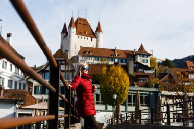 Yetişkin kadın arka plan üzerinde antik kale ile eski köprüde yürürken 