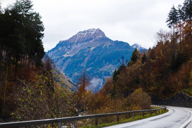 Bulutlu bir günde sonbahar dağlarında yolun manzara görünümü