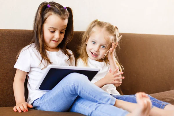 Dos Niñas Pequeñas Usando Touchpad Teléfono Inteligente Sentadas Sofá Casa — Foto de Stock