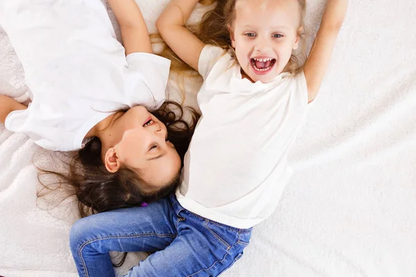 Twee Gelukkige Zusjes Liggend Witte Bed Bovenaanzicht — Stockfoto