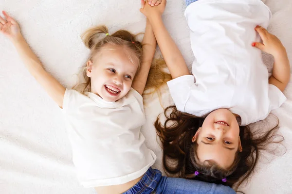 Twee Gelukkige Zusjes Liggend Witte Bed Bovenaanzicht — Stockfoto