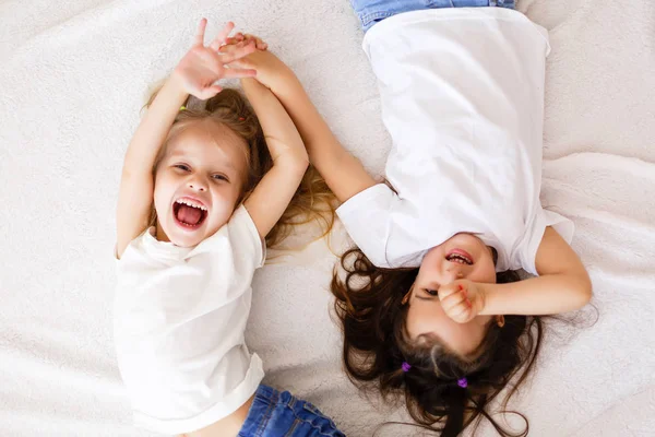 Twee Gelukkige Zusjes Liggend Witte Bed Bovenaanzicht — Stockfoto