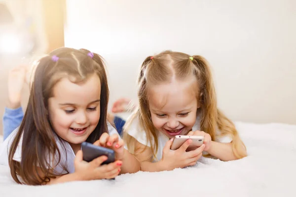 Petites Filles Heureuses Avec Des Smartphones Couchés Sur Sol Maison — Photo