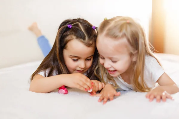 Dos Niñas Pintándose Las Uñas Acostadas Cama Casa — Foto de Stock