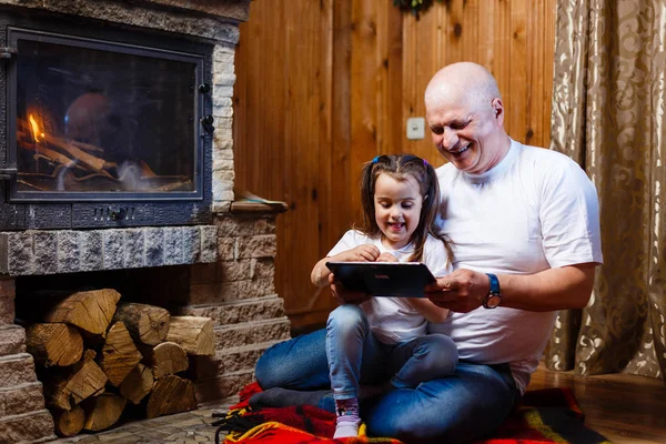 Grandfather Granddaughter Having Fun Using Digital Tablet Sitting Fireplace — Stock Photo, Image