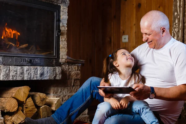 Grandfather Granddaughter Having Fun Using Digital Tablet Sitting Fireplace — Stock Photo, Image