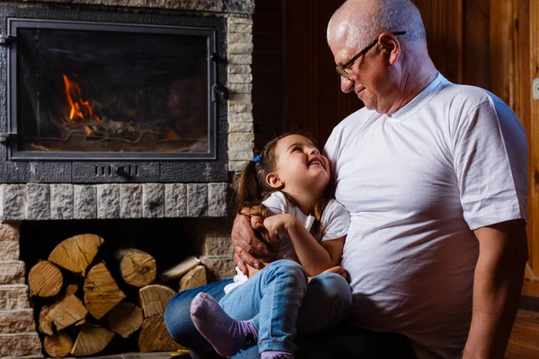 Grandfather Granddaughter Sitting Home Fireplace Hugging — Stock Photo, Image