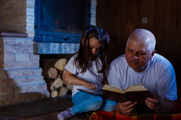 Avô Neta Lendo Livro Usando Tablet Deitado Perto Lareira — Fotografia de Stock