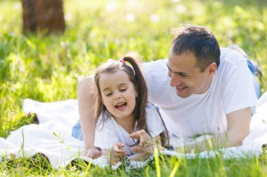 Genç baba ve kız eğleniyor yeşil çim üzerinde yalan