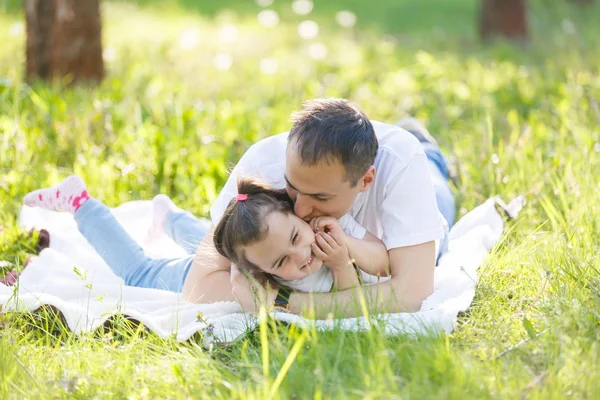 若い父親と娘の楽しい緑の草の上に横たわる — ストック写真