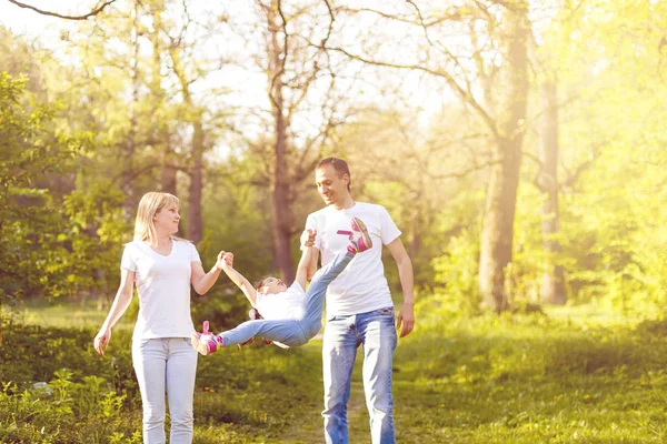 Linda Niña Saltando Cogida Mano Con Los Padres Caminando Parque —  Fotos de Stock