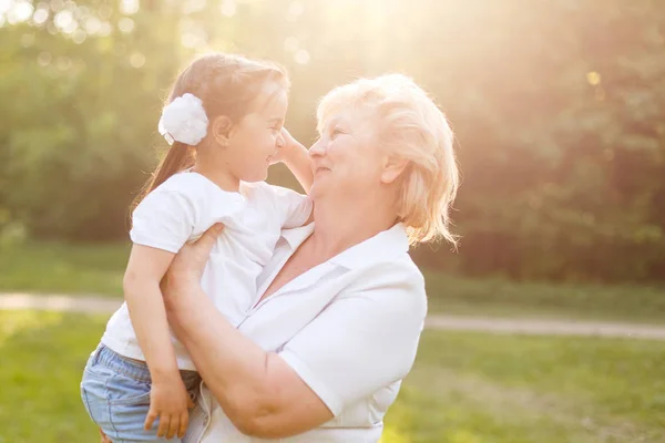 Grand Mère Portant Petite Fille Souriant Debout Extérieur — Photo