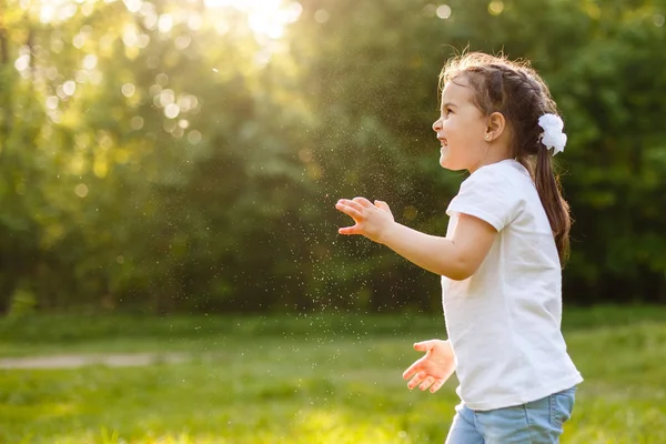 可爱的卷发女孩在绿色花园里玩肥皂泡 快乐童年概念 — 图库照片