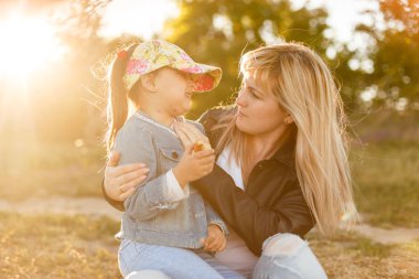Sevimli genç kızı bir domuz sırtına binmek annesi ile.
