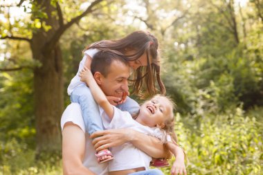 Mutlu baba iki küçük kızı ile yeşil park eğlenmek