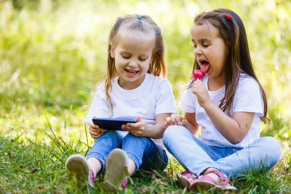 Dwie Małe Dziewczynki Roześmiany Siedzieć Razem Odkrytym Mieście Grać Smartphone — Zdjęcie stockowe