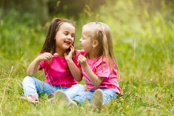 Two Cute Little Sisters Eating Lollipops Green Summer Park Stock Image