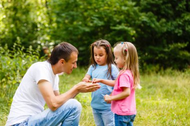 Baba küçük kızı yeşil park ile oynarken