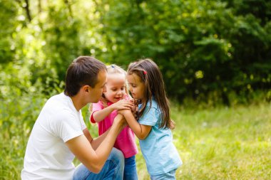 Baba küçük kızı yeşil park ile oynarken
