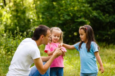 Baba küçük kızı yeşil park ile oynarken