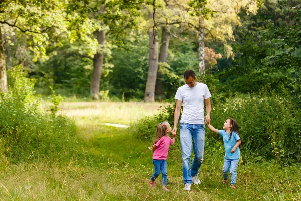Счастливый Отец Держащийся Руки Двух Маленьких Дочерей Гуляющих Зеленом Парке — стоковое фото