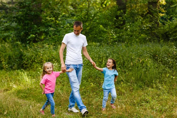 Pai Feliz Mãos Dadas Duas Filhas Caminhando Parque Verde — Fotografia de Stock