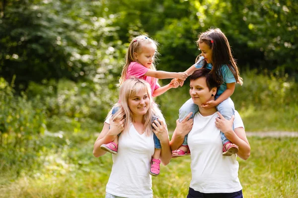 Deux Femmes Heureuses Marchant Avec Des Enfants Sur Les Épaules — Photo