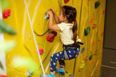 küçük kız kapalı sarı taş duvara tırmanma