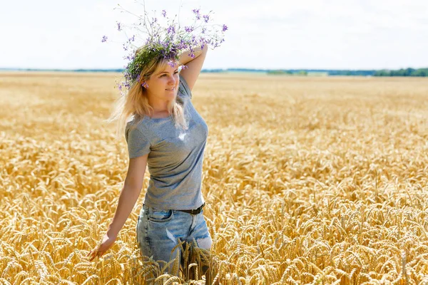 麦畑にフローラル リース立って若い女性 — ストック写真
