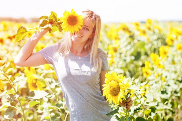 ひまわり自然を楽しんでいると夏のひまわりの畑に笑ってうれしそうな美少女 — ストック写真