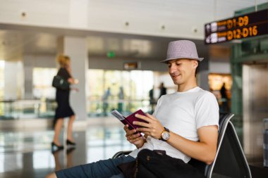 dostum giyen şapka holding pasaport ve yatılı havaalanında geçmek