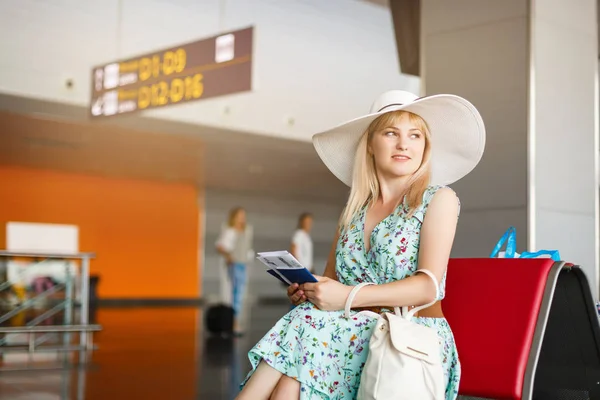 Красивая Молодая Женщина Шляпе Держащая Билеты Паспорта Сидя Терминале Аэропорта — стоковое фото