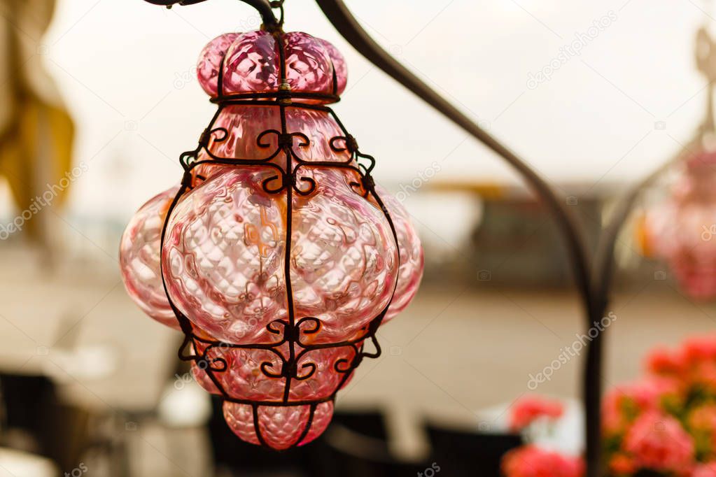 Ancient pink murano glass lamps on a street in Venice