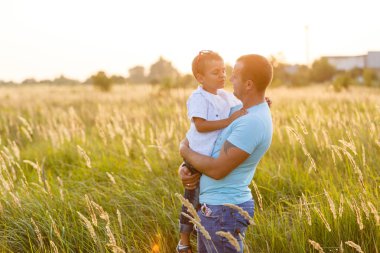 Oğlu alanında günbatımında yürüyüş ellerinde babamla