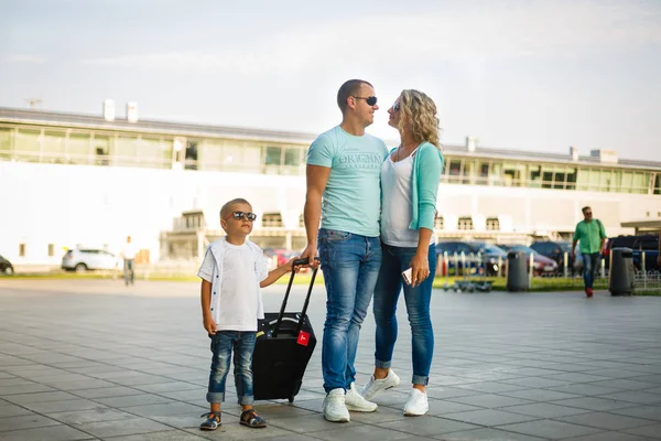 Happy family with luggage in airport ready to travel