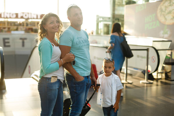 Happy family with luggage in airport ready to travel