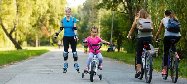 Giovane Madre Pattinaggio Rotelle Con Piccola Figlia Bicicletta Parco — Foto Stock
